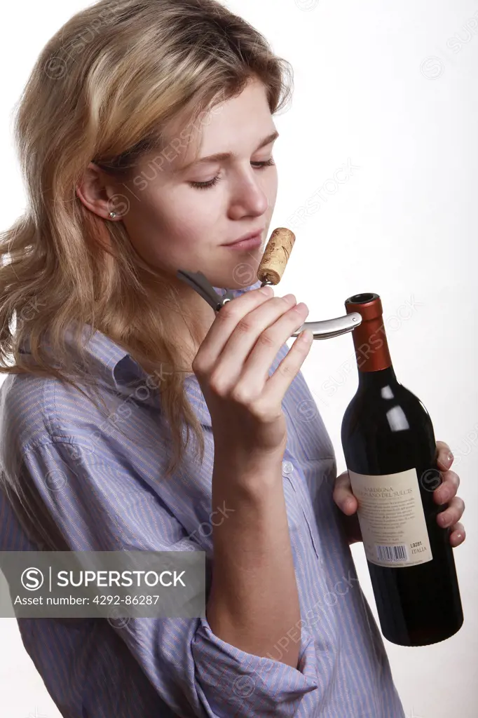 woman smelling wine cork