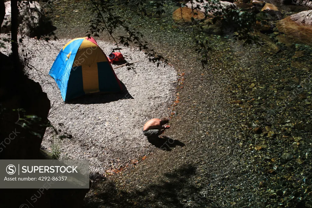 Man camping on river bank