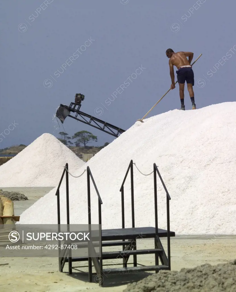 Man working in saltworks, Italy, Sicily, Marsala