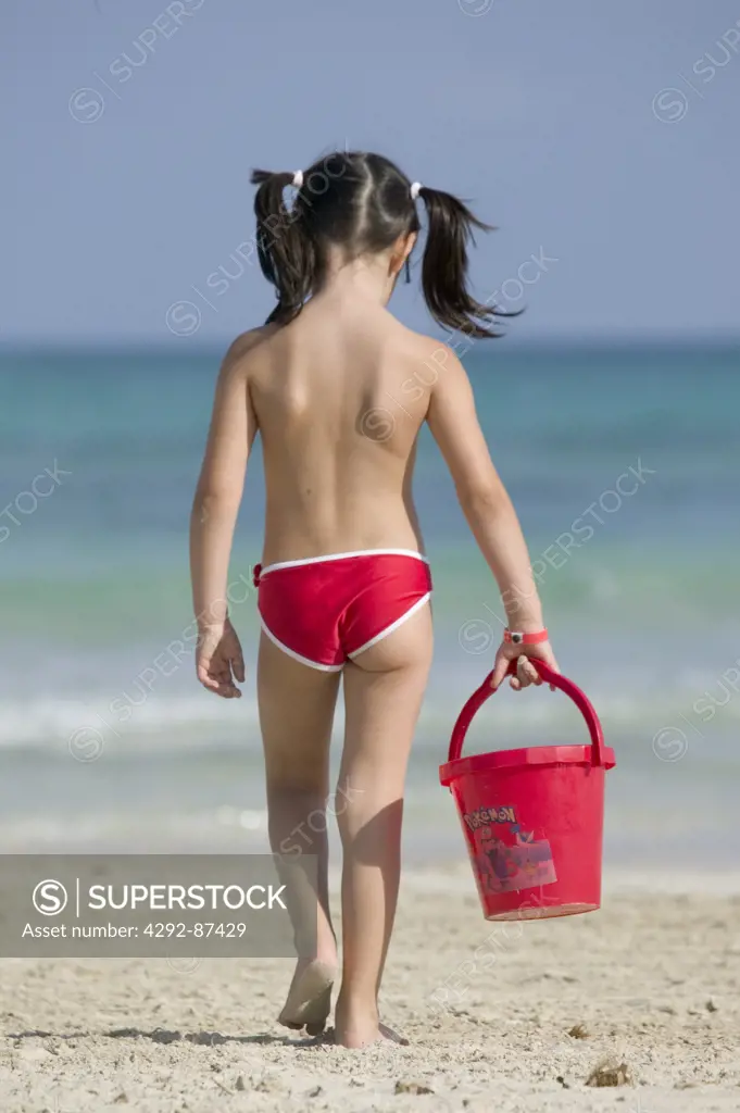 Rear view of a girl walking on the beach