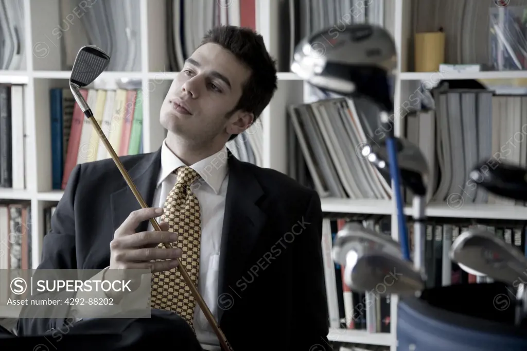 Businessman at office looking at golf club