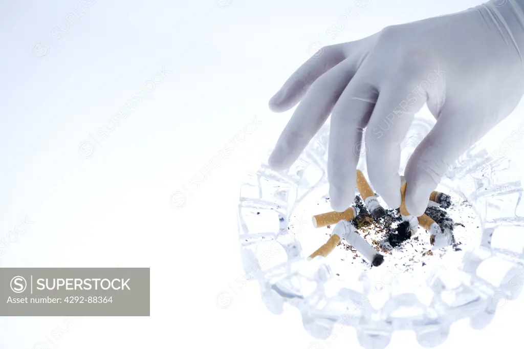 Hand putting out cigarette in ashtray