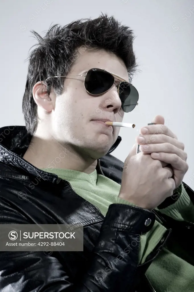 Young man lighting a cigarette