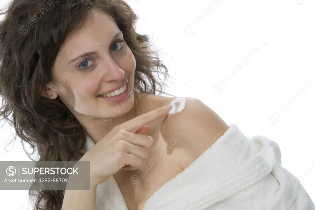 Woman putting cream on her shoulder