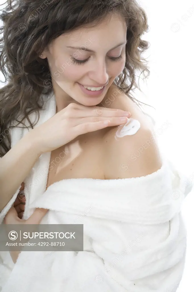 Woman putting cream on her shoulder