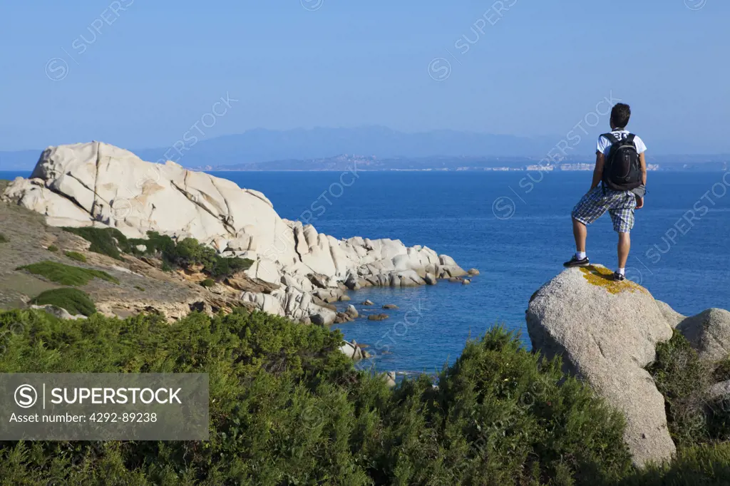 Italy, Sardinia, Capo Testa, man standing on rock