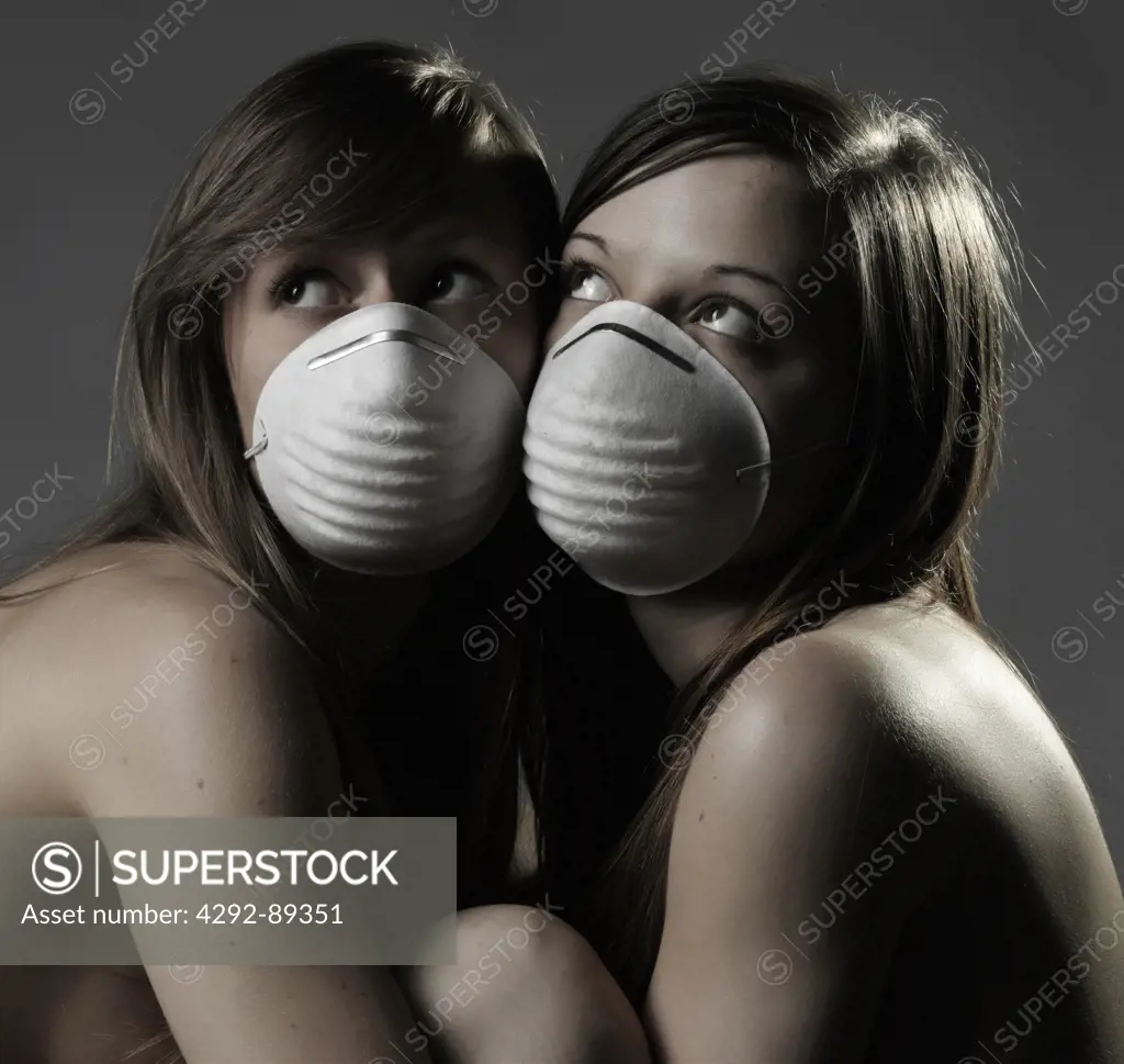 Studio shot of two women wearing flu mask