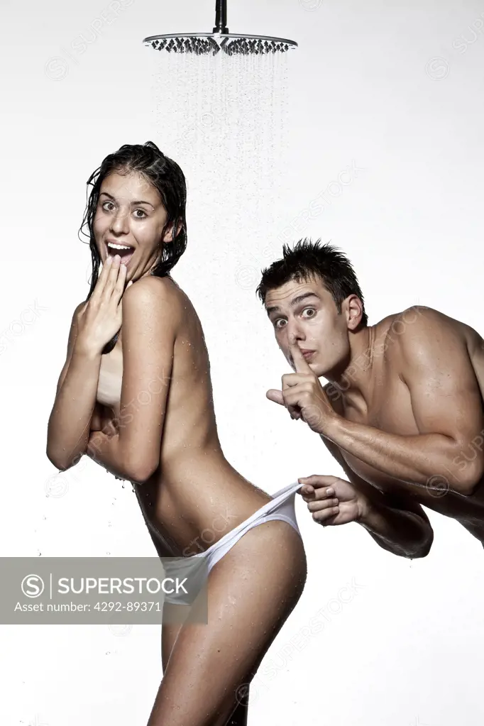 Couple under shower, man pulling back waistband of woman's panties