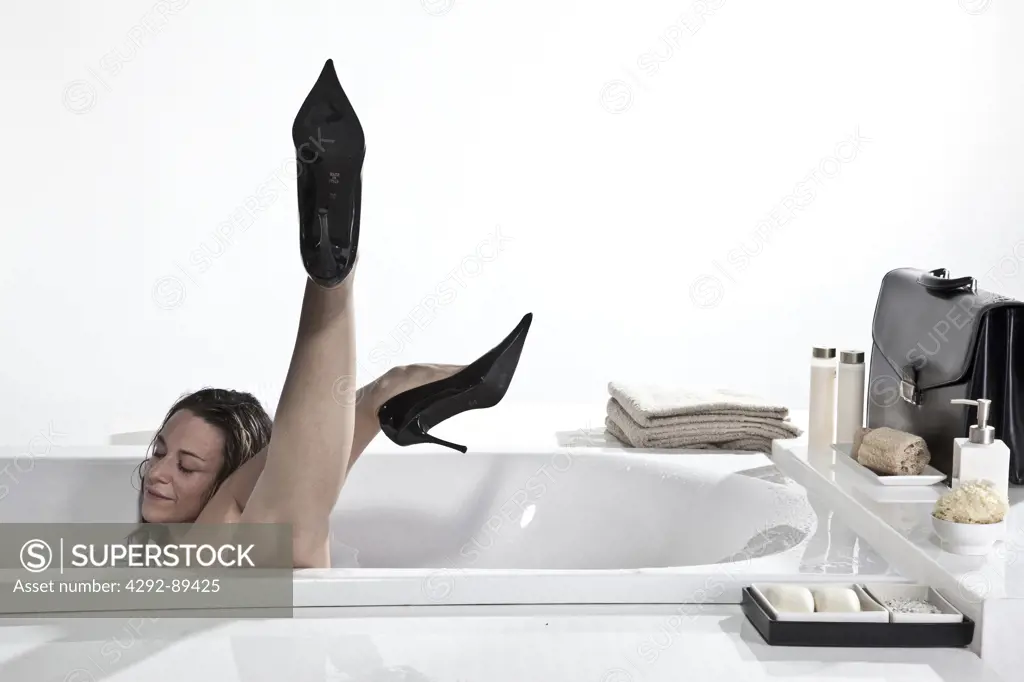 Businesswoman asleep in bathtub