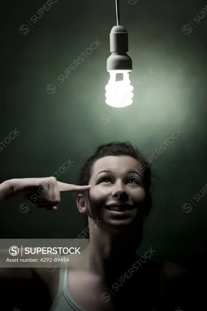 Young woman looking at energy efficient lightbulb