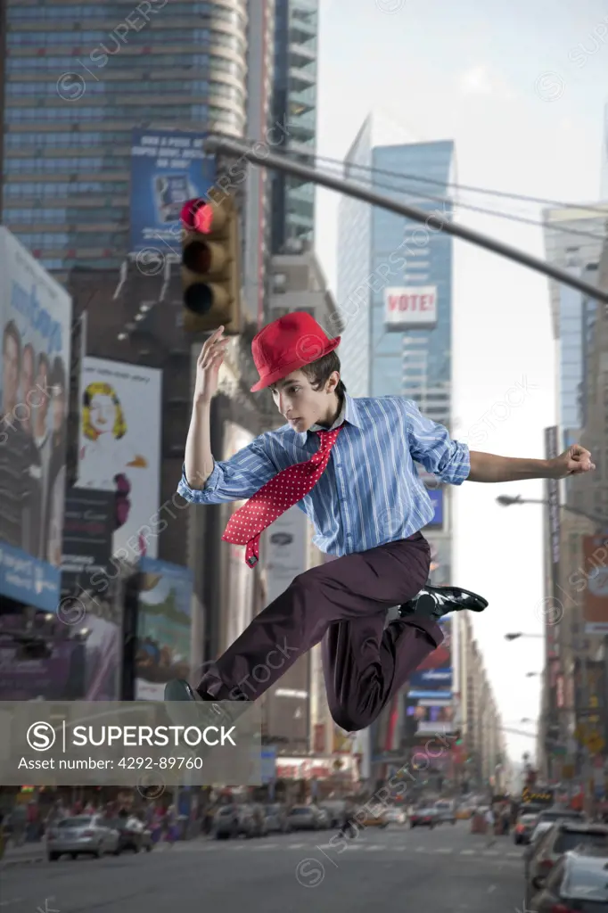 USA, New York City, tenneager jumping in Times square