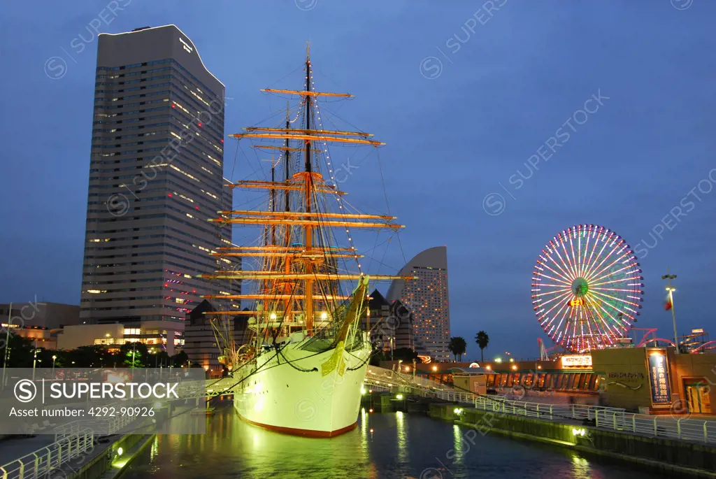 Japan, Yokohama, Illuminated sailing ship and big wheel in Yokohama Minato Mira