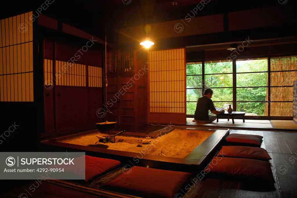 Japan, man sitting in a traditional wooden house