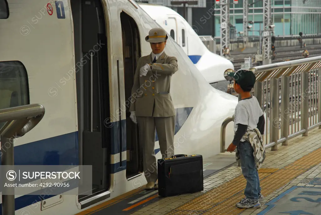 Japan, Tokyo, woman and boy in front of Shinkansen train at the station
