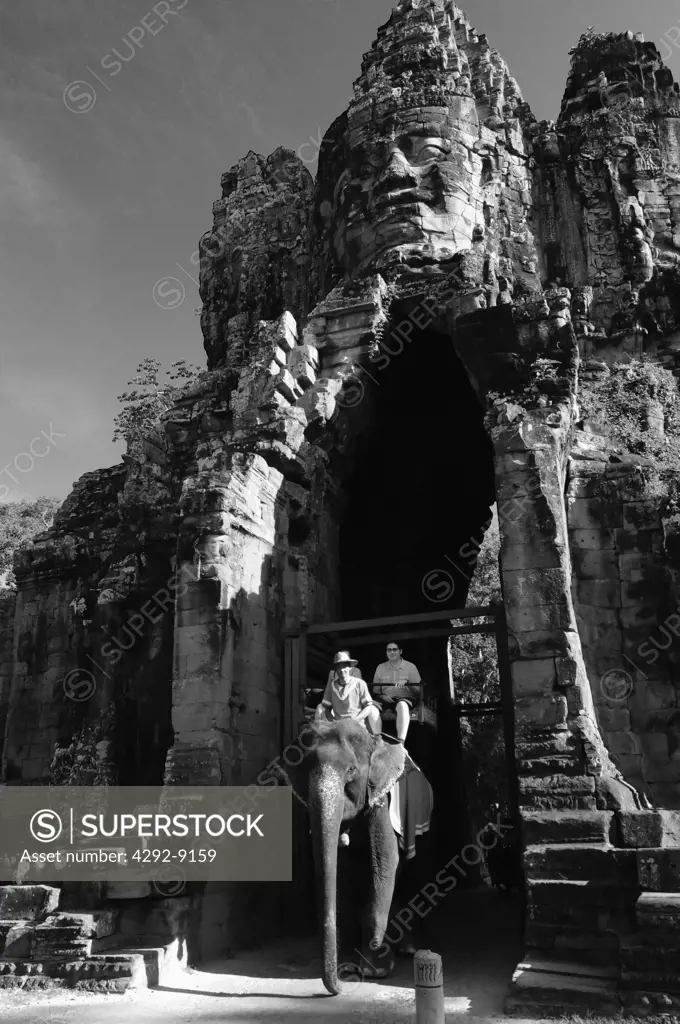 Asia, Cambodia, Siem Reap, Angkor Wat, tourist riding elephant at the entrance to the Bayon temple in Angkor Thom complex