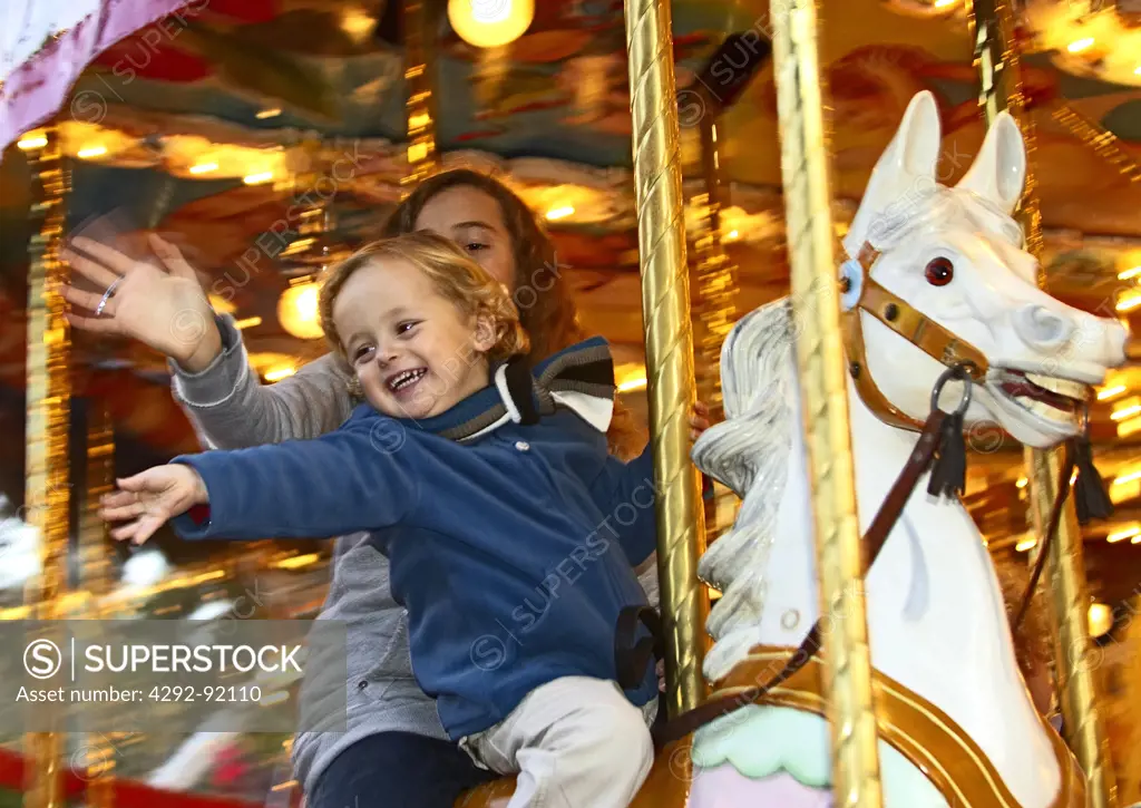 Belgium, Liege, October fairground, boy whipping a horse on carrousel