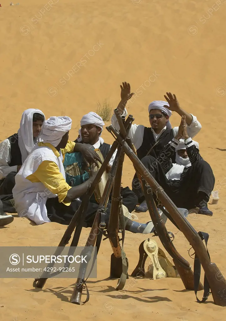 Africa, Algeria, Saoura area, Sahara desert, hunters sitting on sand hill