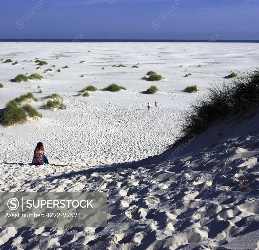 Germany, Schleswig-Holstein, Hallingen, Amrum island, woman sitting on beach