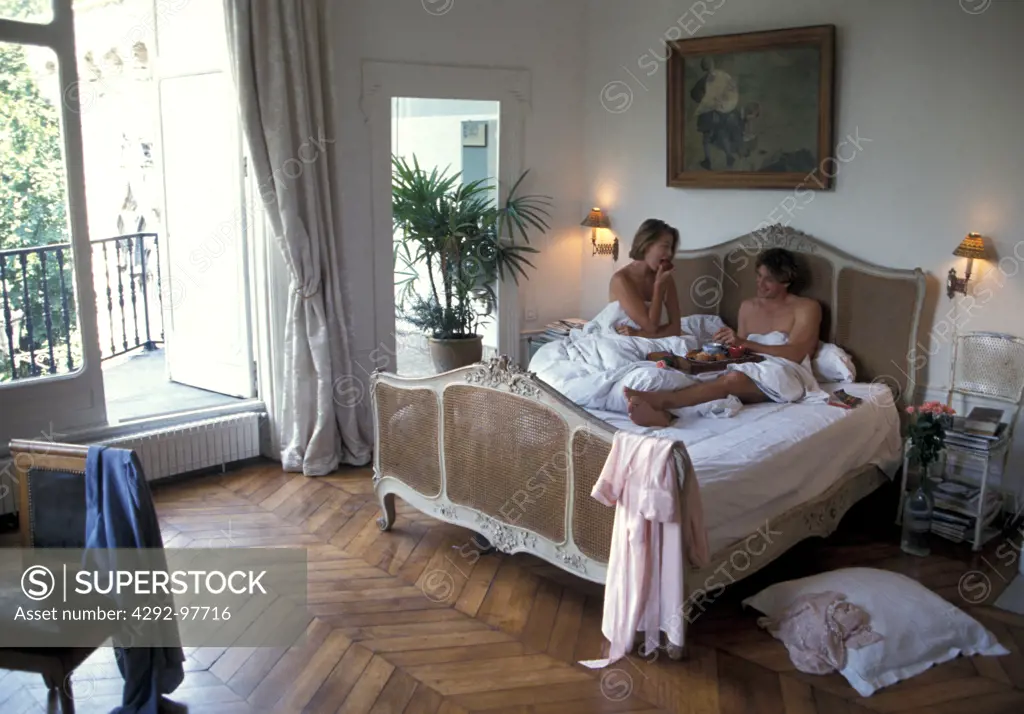 Couple in bedroom having breakfast