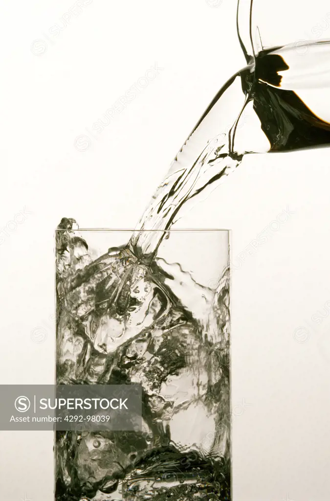 Pouring water into a glass with ice