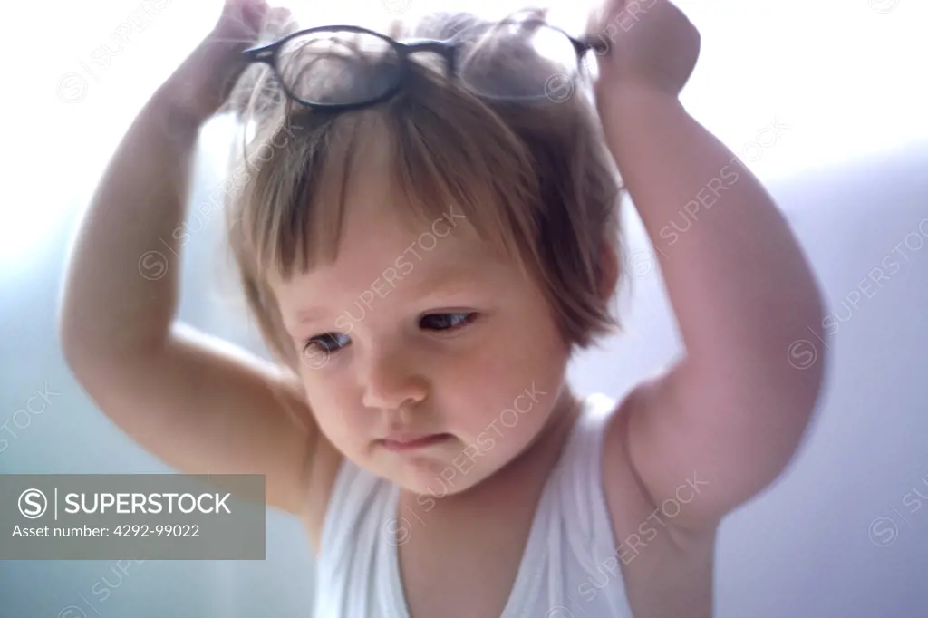 Little girl playing with eye-glasses