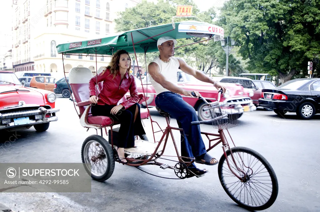 Cuba, Havana, woman riding in cyclo rickshaw