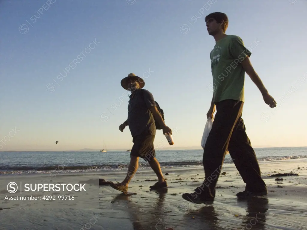 USA, California, Santa Barbara men walking on beach