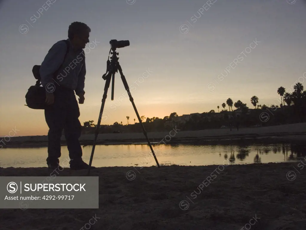USA, California, Santa Barbara, photographer on beach at sunset