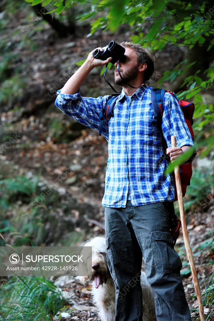 Man and dog trekking in forest