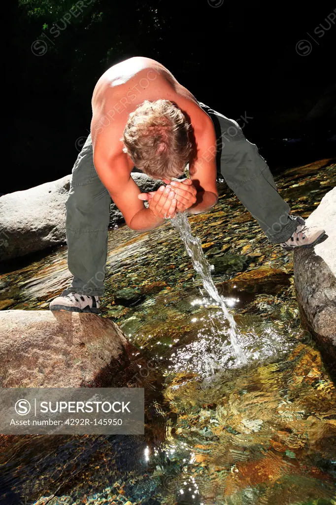 Man washing face in stream