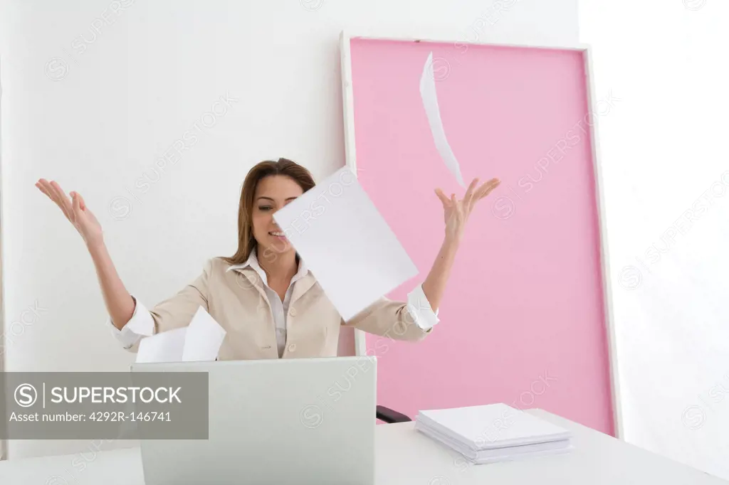 Businesswoman throwing office papers