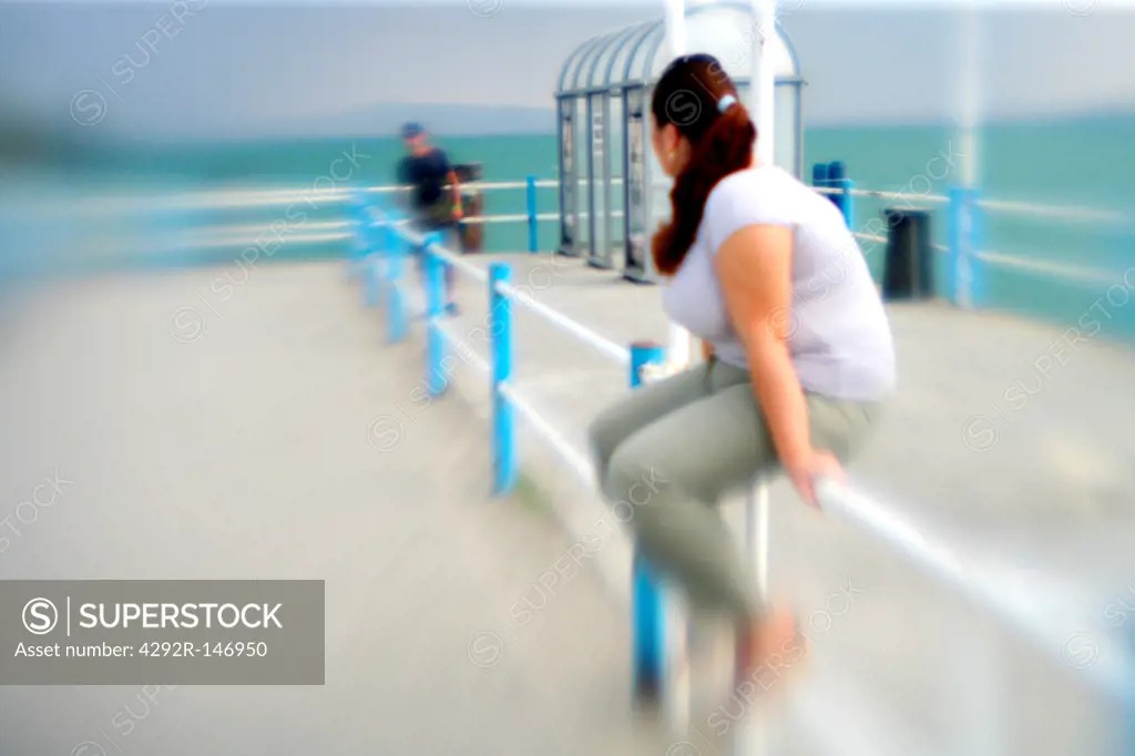 Woman sitting on railing