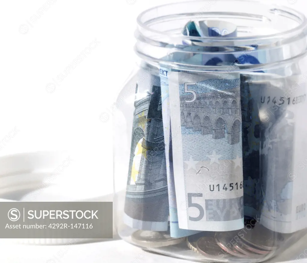 Euro coins and banknotes in jar