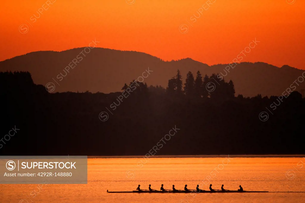 Silhouette of men's eights rowing team in action