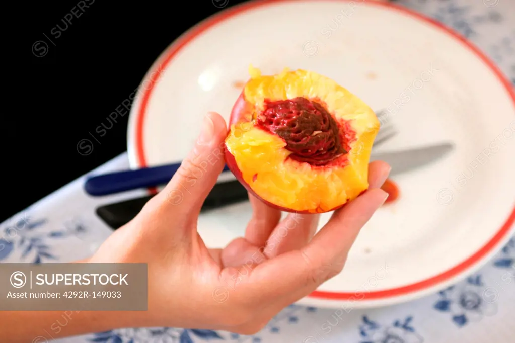 Woman's hand holding a peach