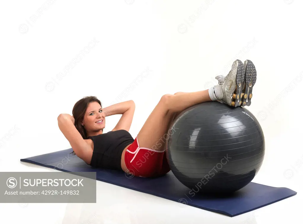 Woman exercising with fitness ball, studio shot