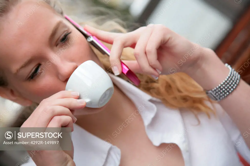 Woman drinking coffee and using mobile