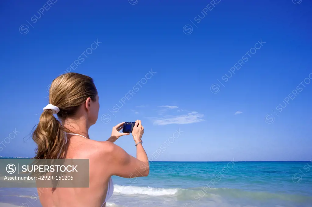 Woman in bikini taking photo of the Caribbean Sea in Playa del Carmen,Mexico