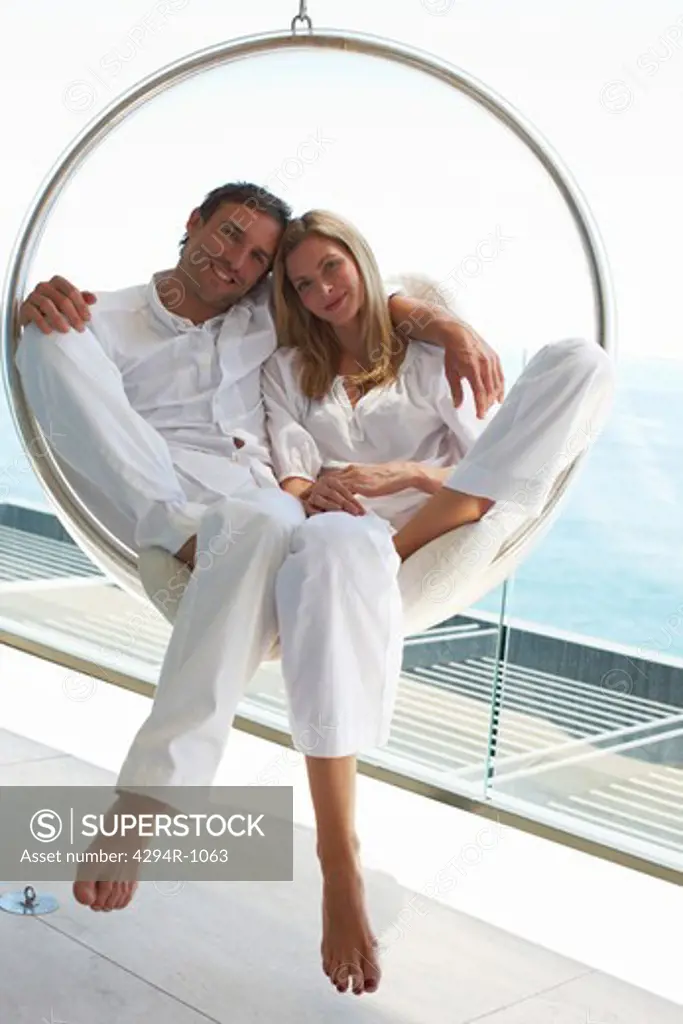 Couple relaxing in hanging chair