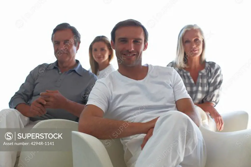 Man sitting with parents and wife in the background