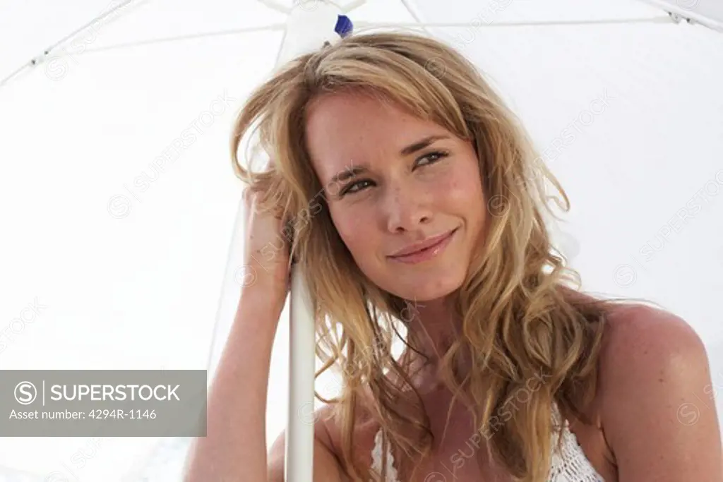 Blond young woman with sunshade