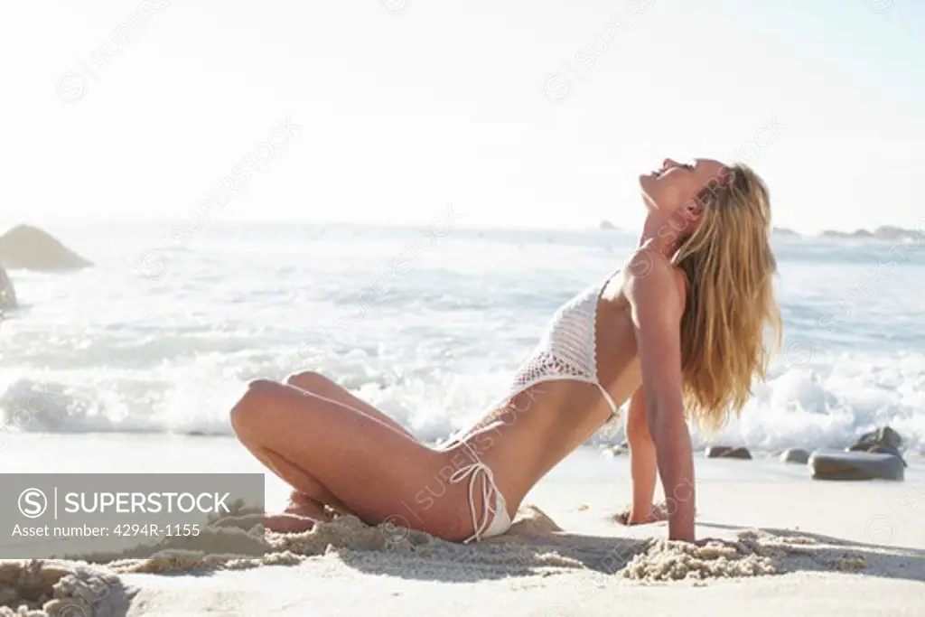 Blond young woman relaxing on beach