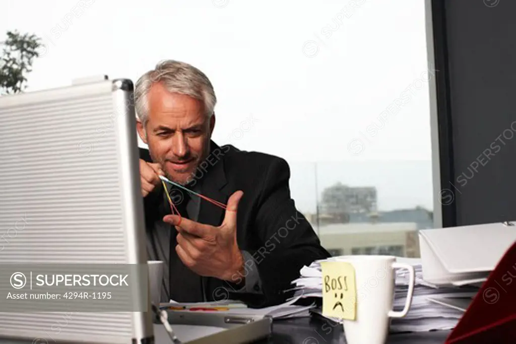 Playful businessman at desk in office