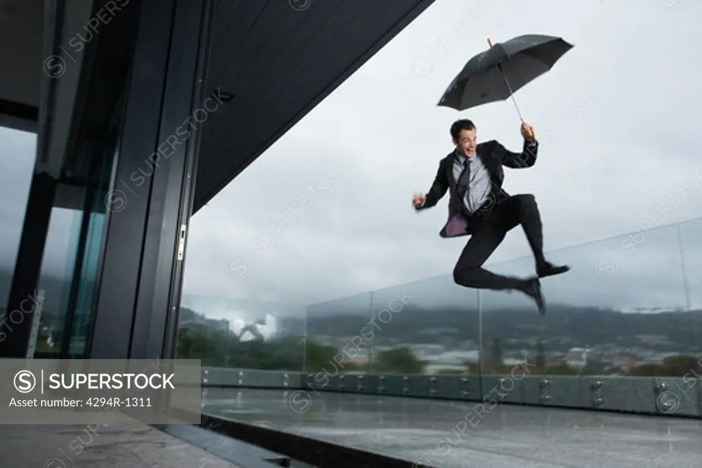 Happy businessman in the rain