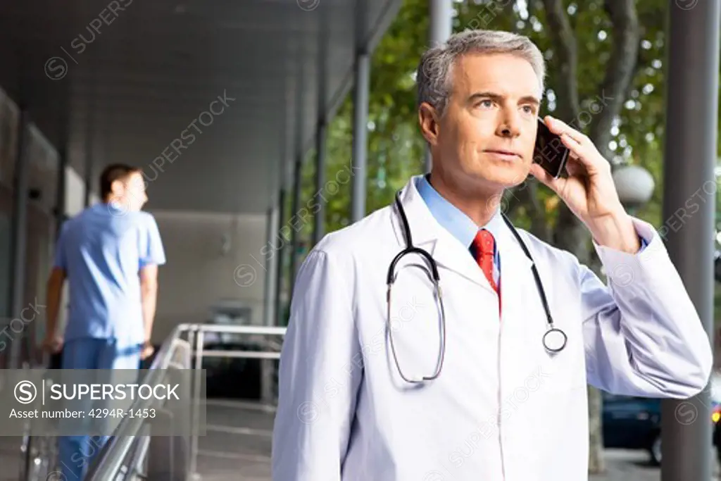 Doctor on the phone outside hospital