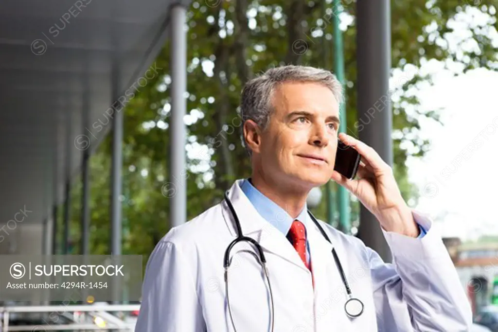 Doctor on the phone outside hospital