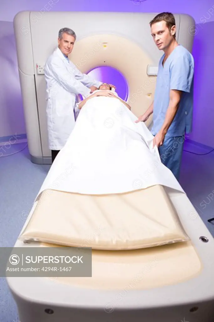 Doctors with patient at CT scanner