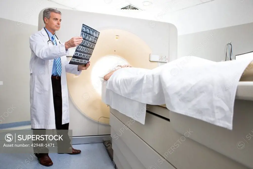 Doctor with patient and x-ray at CT scanner