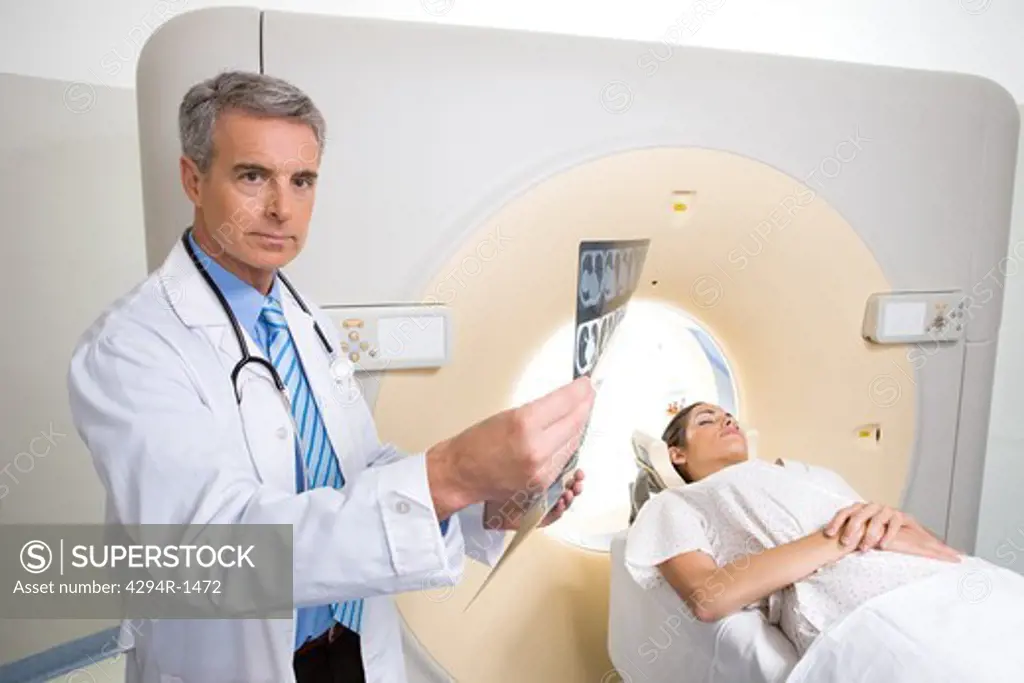 Doctor with patient and x-ray at CT scanner