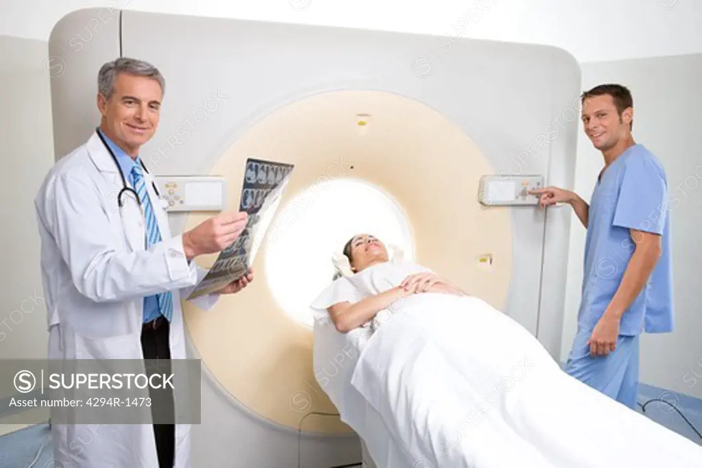 Doctors with patient and x-ray at CT scanner